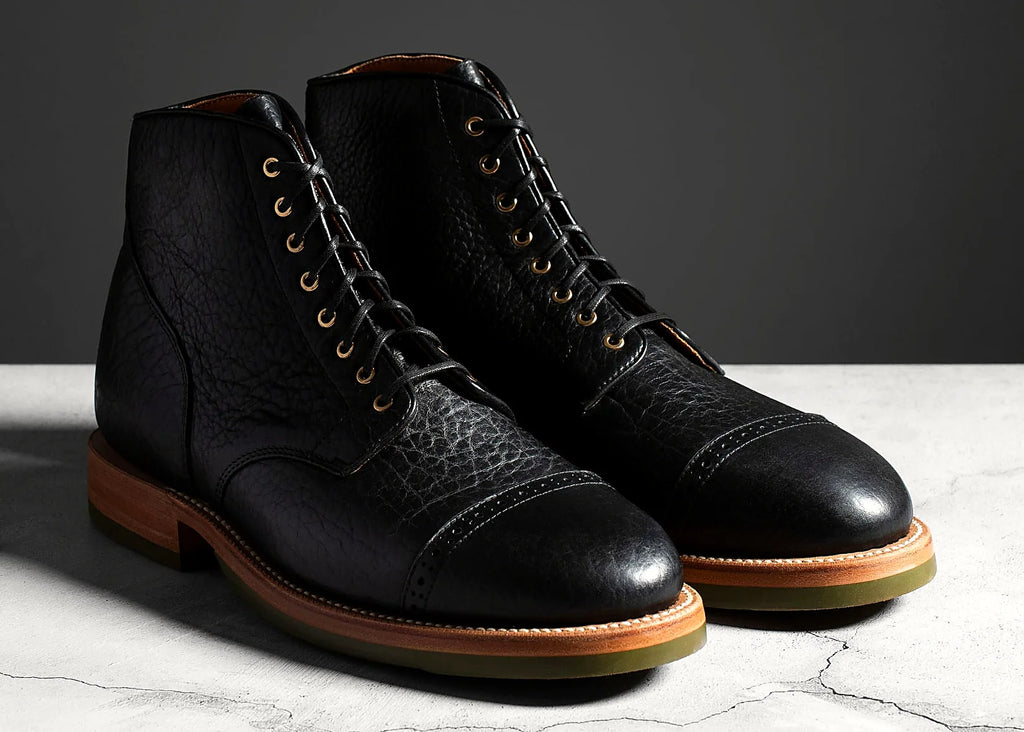Black perforated cap toe service boot in American Bison, set on a Dr. Sole Supergrip half sole