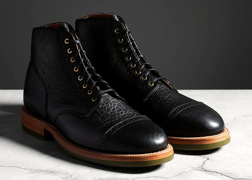 Black perforated cap toe service boot in American Bison, set on a Dr. Sole Supergrip half sole