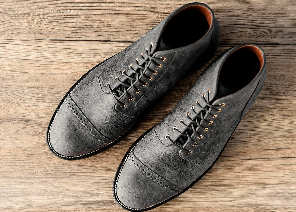 perforated cap toe service boot in Storm grey Waxed Kudu with polished brass eyelets